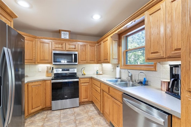 kitchen featuring appliances with stainless steel finishes, decorative backsplash, sink, and light tile patterned floors