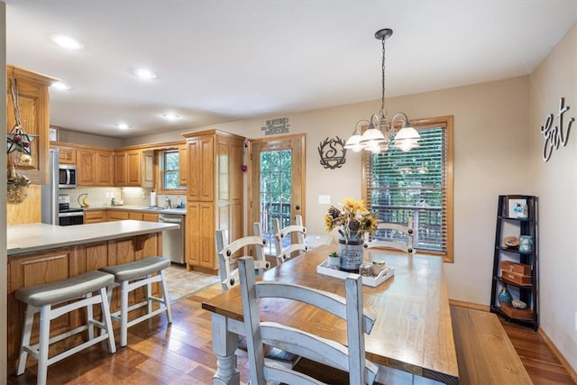 dining room featuring an inviting chandelier, light wood-type flooring, and sink