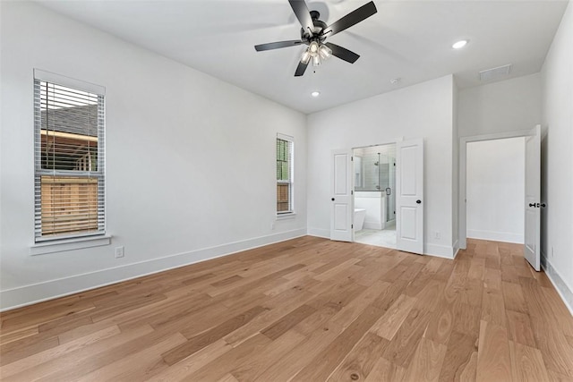 unfurnished bedroom featuring ensuite bath, ceiling fan, and light wood-type flooring