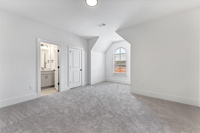 additional living space with lofted ceiling and light carpet