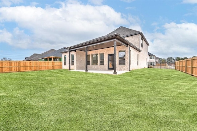 rear view of property featuring a yard and a patio area