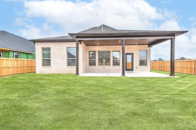 rear view of property featuring a yard and a patio area