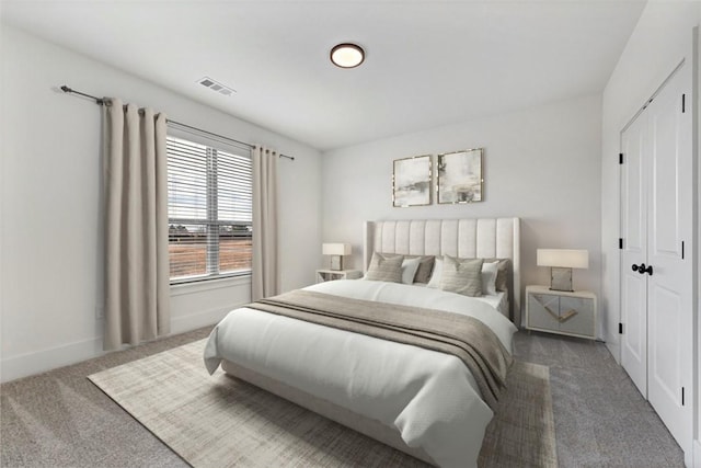 carpeted bedroom with a closet, visible vents, and baseboards