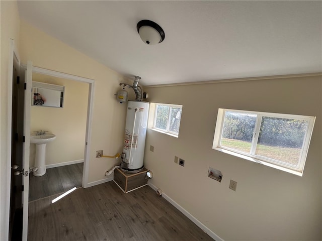 laundry area featuring gas water heater, hookup for an electric dryer, dark hardwood / wood-style floors, and sink