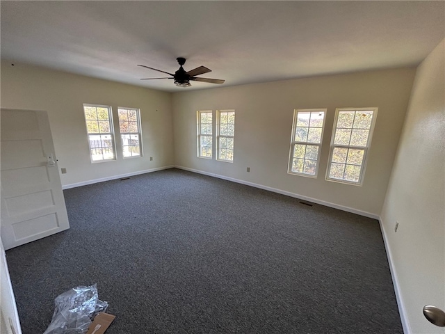 carpeted empty room with ceiling fan and a healthy amount of sunlight