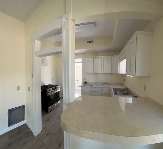 kitchen featuring dark hardwood / wood-style flooring, white cabinets, sink, and stainless steel gas range