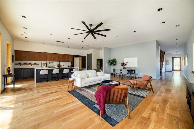 living room featuring ceiling fan and light hardwood / wood-style flooring