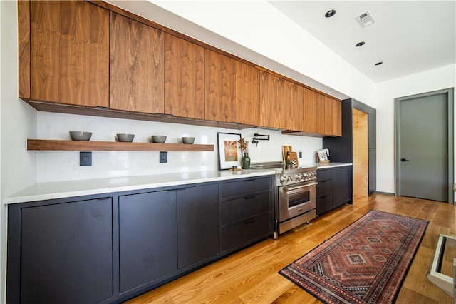 kitchen featuring light wood-type flooring and high end stainless steel range