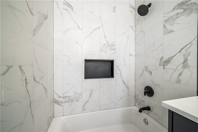 bathroom featuring vanity and tiled shower / bath