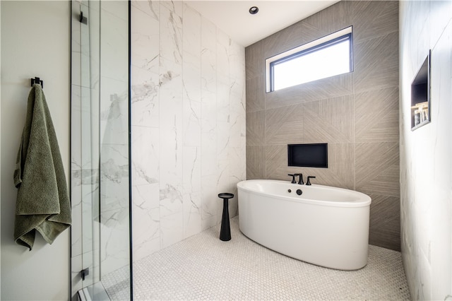 bathroom featuring tile patterned floors, plus walk in shower, and tile walls