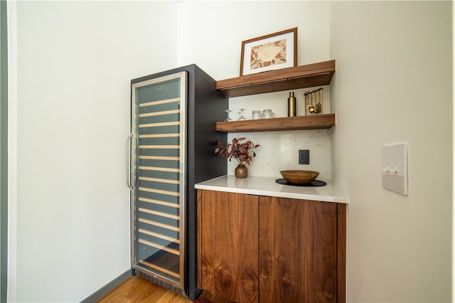 bar featuring light hardwood / wood-style floors and wine cooler