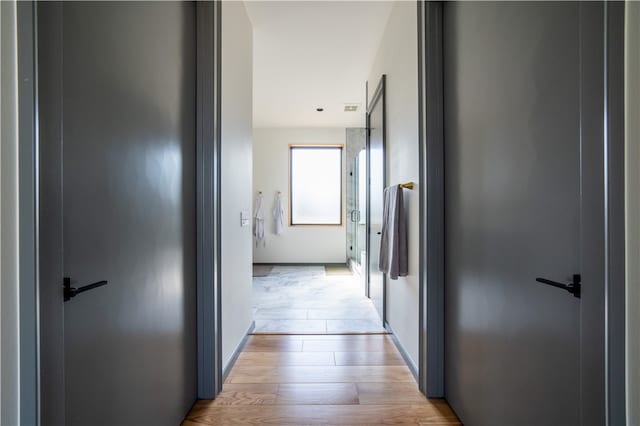 hallway with light hardwood / wood-style floors