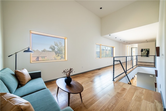 living room featuring a towering ceiling and light wood-type flooring