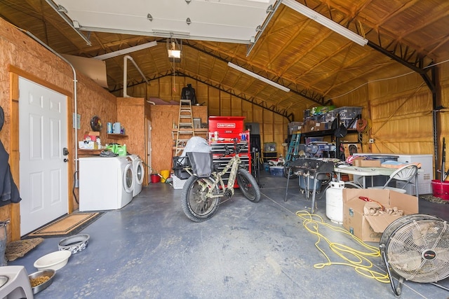 garage featuring wooden walls and washing machine and clothes dryer