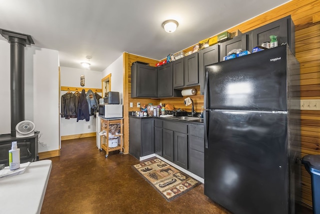 kitchen with sink, decorative columns, and black refrigerator