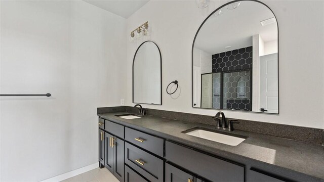 bathroom featuring tile patterned flooring, a shower with shower door, and vanity