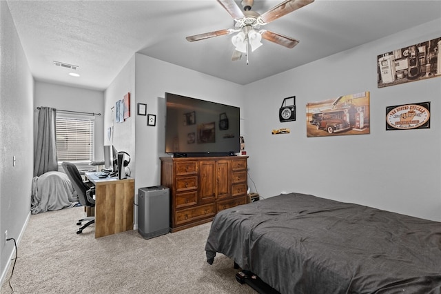 bedroom with light carpet, a textured ceiling, and ceiling fan