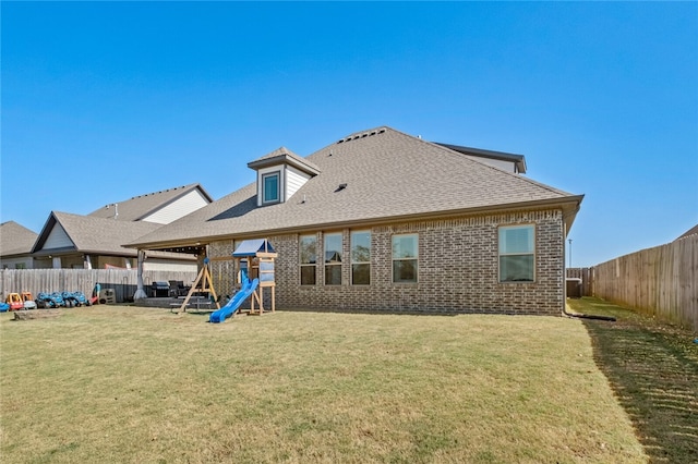 back of house with a playground and a yard