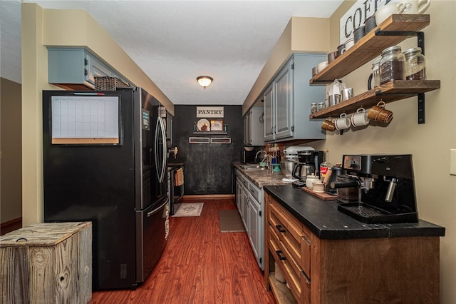 kitchen with dark hardwood / wood-style flooring, a textured ceiling, black appliances, gray cabinets, and sink