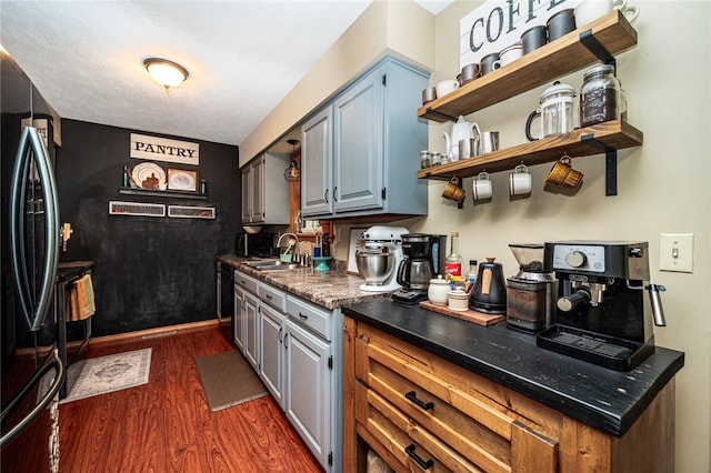 kitchen featuring gray cabinetry, sink, dishwasher, fridge, and dark hardwood / wood-style flooring