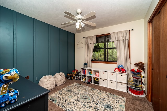 bedroom with a closet, ceiling fan, carpet flooring, and a textured ceiling