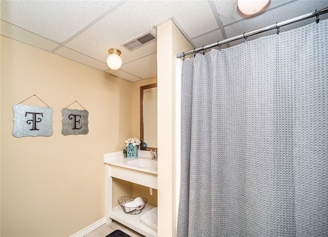 bathroom featuring sink, a shower with curtain, and a paneled ceiling