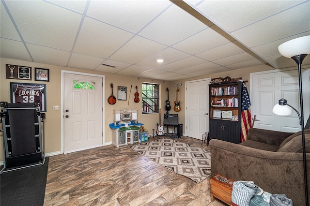 living room featuring a drop ceiling and hardwood / wood-style flooring