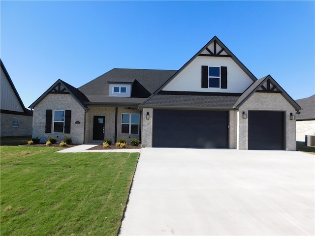 view of front of home with a front lawn, central AC unit, and a garage