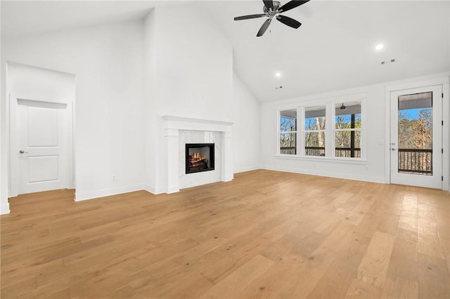 unfurnished living room featuring ceiling fan, high vaulted ceiling, a fireplace, and light hardwood / wood-style flooring