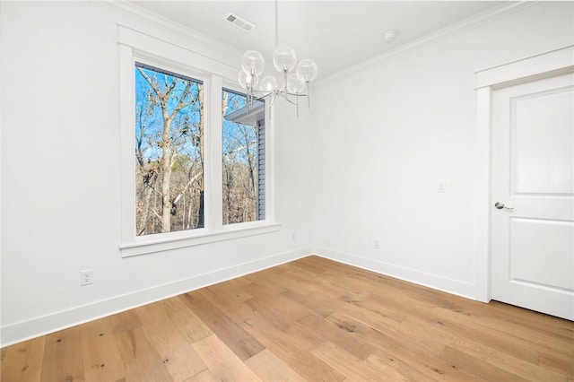 unfurnished dining area featuring light hardwood / wood-style flooring, crown molding, and a notable chandelier