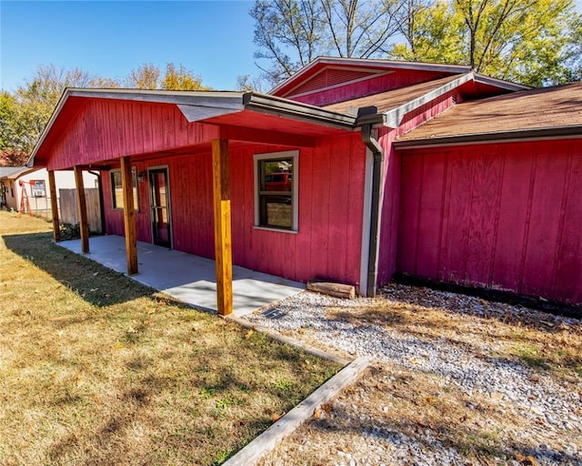 view of side of property featuring a yard and a patio area