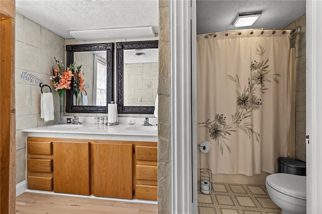 bathroom with vanity, a textured ceiling, hardwood / wood-style flooring, and toilet