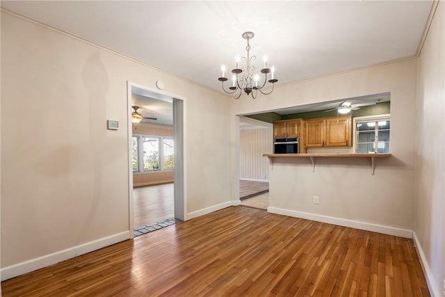 interior space featuring ornamental molding, wood finished floors, and baseboards