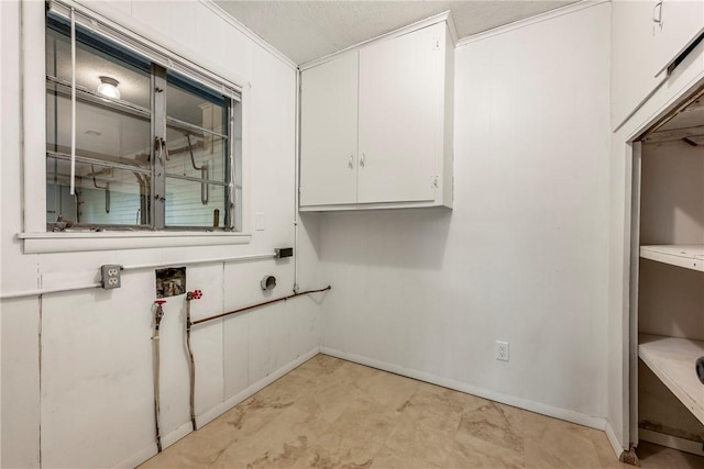 washroom with cabinet space and baseboards