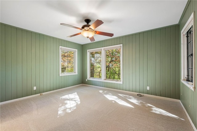 unfurnished room featuring carpet flooring, ceiling fan, and baseboards