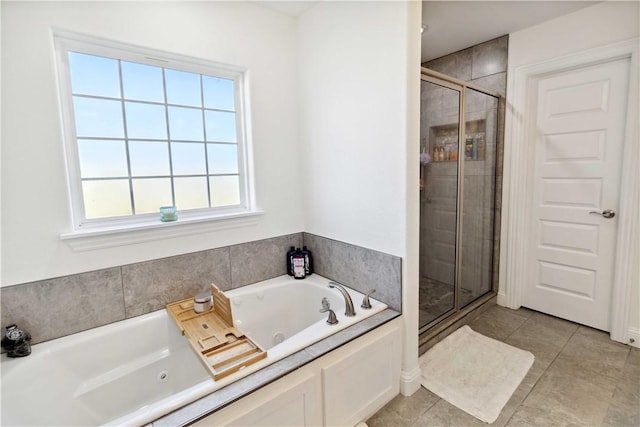 bathroom with a wealth of natural light, a shower stall, tile patterned flooring, and a jetted tub