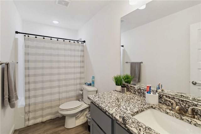 full bathroom featuring vanity, toilet, shower / bath combo with shower curtain, and hardwood / wood-style floors