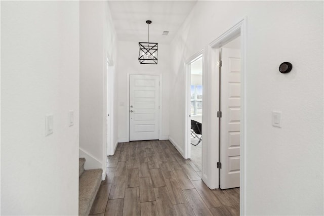 hallway featuring stairs, wood finished floors, and baseboards