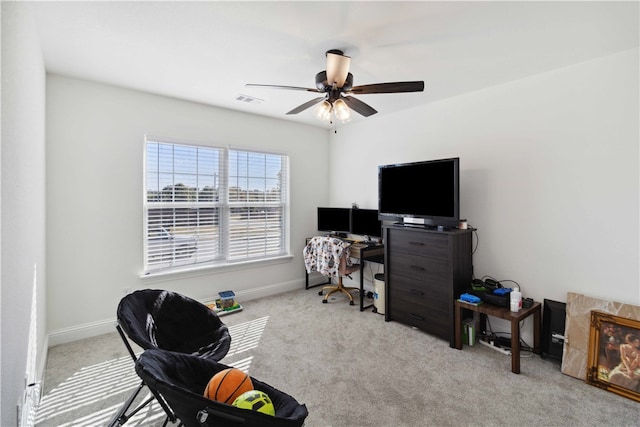 carpeted office space with ceiling fan