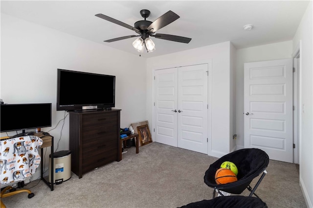 interior space featuring light carpet and ceiling fan