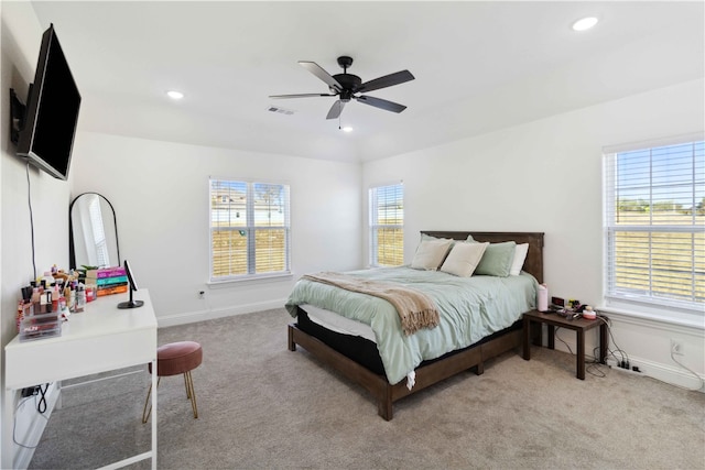 carpeted bedroom featuring multiple windows and ceiling fan