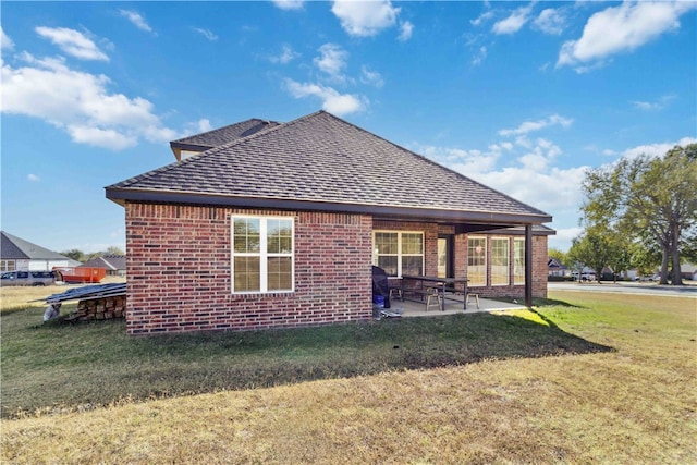 back of house with a patio and a lawn