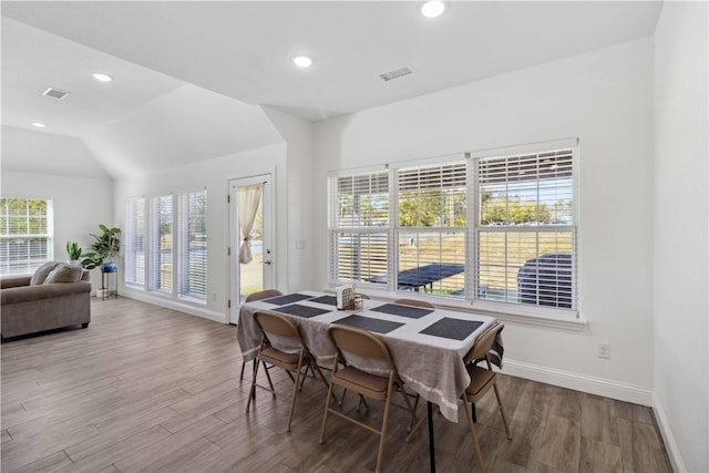 dining area with hardwood / wood-style floors and vaulted ceiling