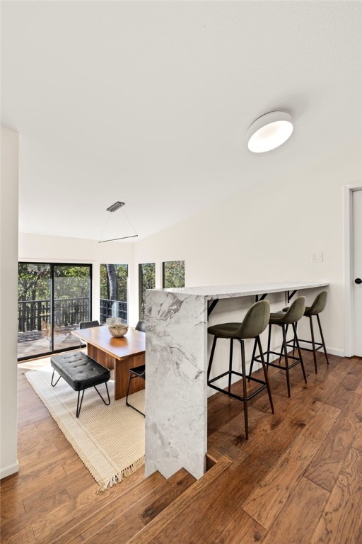 dining space featuring hardwood / wood-style flooring and vaulted ceiling