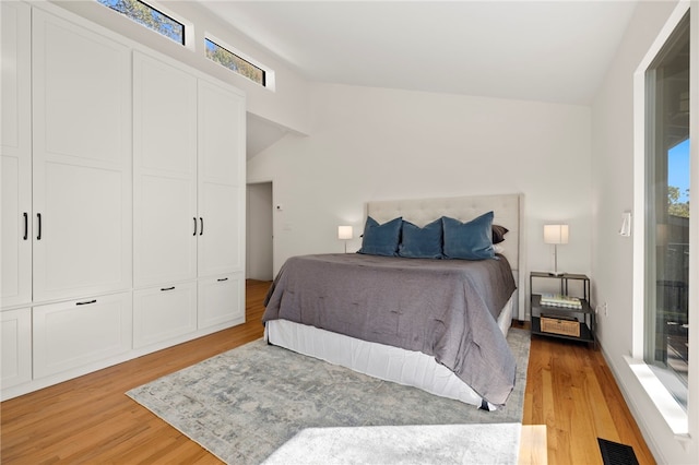 bedroom featuring a closet, vaulted ceiling, and light wood-type flooring