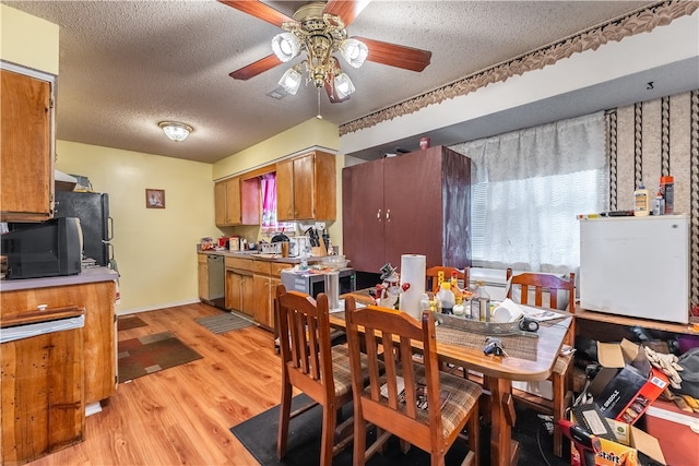 dining room with ceiling fan, a textured ceiling, and light hardwood / wood-style flooring