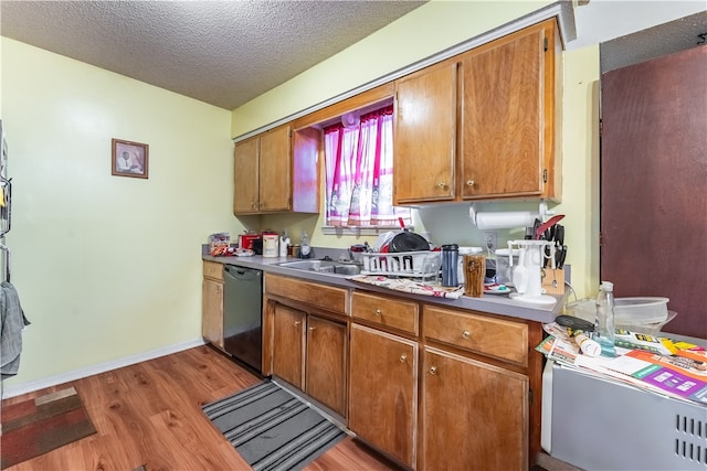 kitchen featuring light hardwood / wood-style floors, a textured ceiling, black dishwasher, and sink