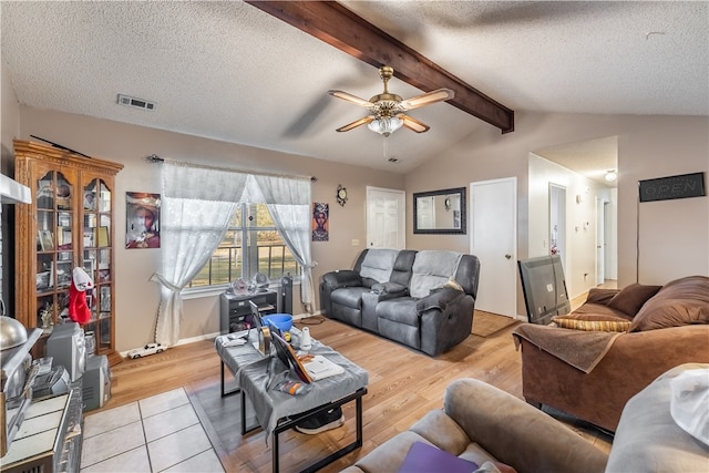 living room with light hardwood / wood-style floors, a textured ceiling, vaulted ceiling with beams, and ceiling fan