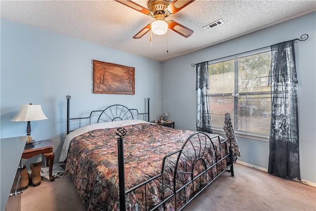 carpeted bedroom with a textured ceiling and ceiling fan