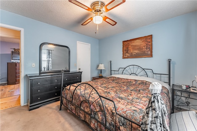 carpeted bedroom featuring a textured ceiling and ceiling fan